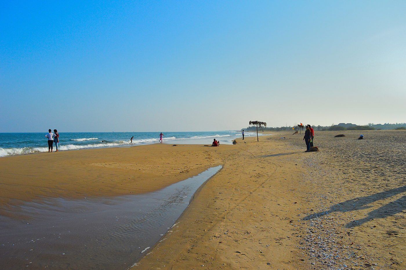 Palm-lined sand and blue water at Paradise Beach near Pondicherry