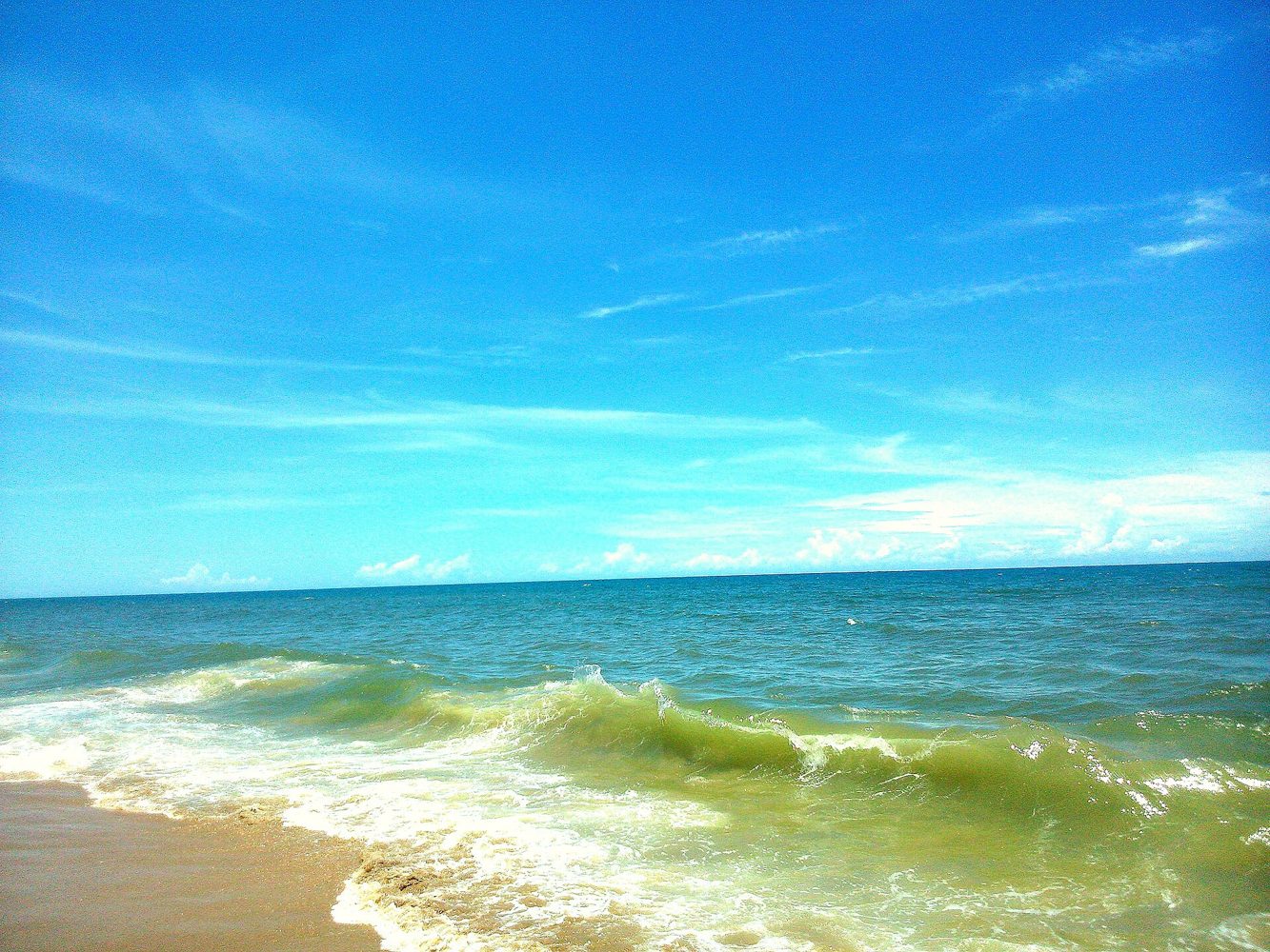 Blue sea and sandy shoreline at Auroville Beach near Pondicherry